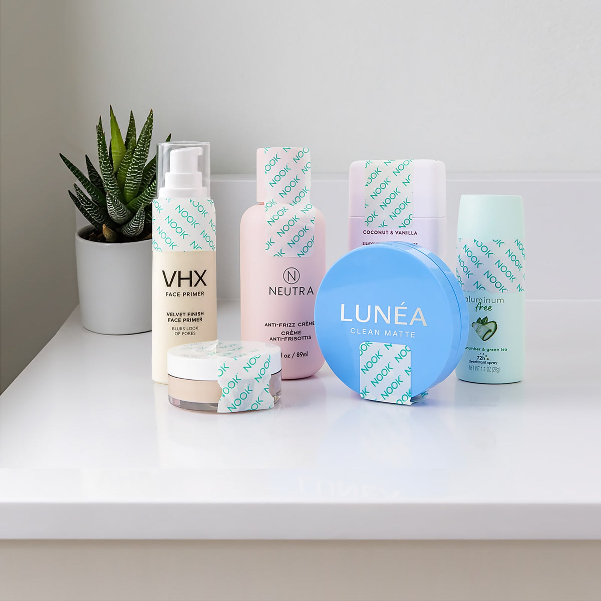 NOOK Travel Sealing Tape wrapped around bathroom and skincare products on a white shelf