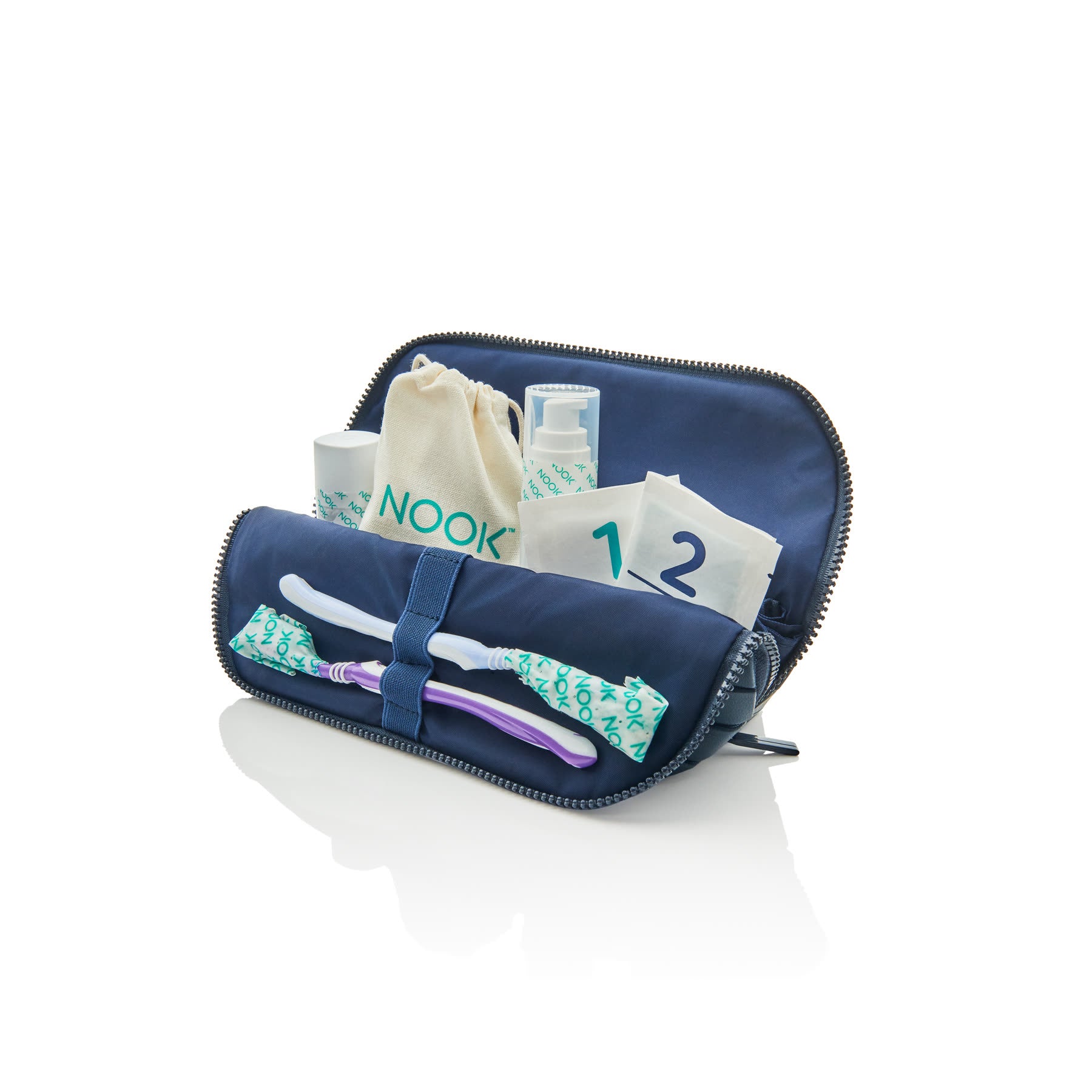 NOOK travel toiletry bag open showing the toothbrush wrap, toiletry tape, and travel bottles inside